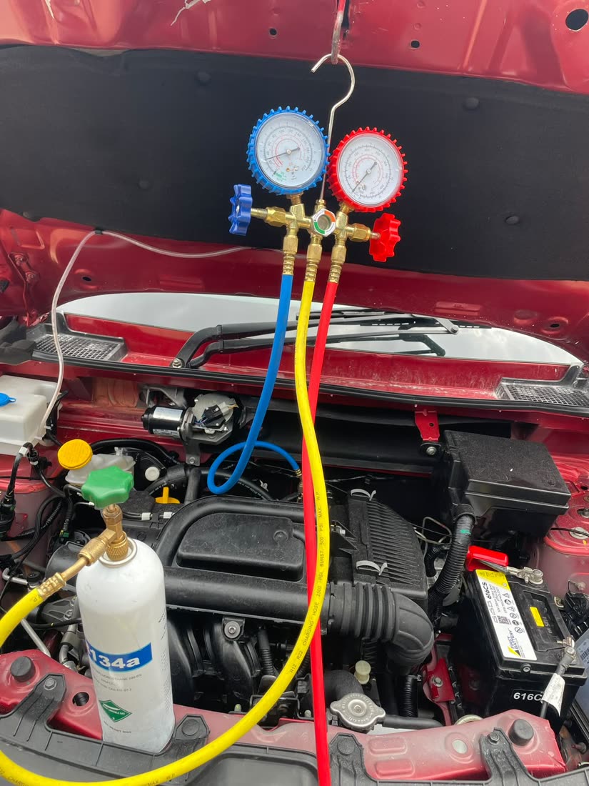 Refrigerant cylinder and gauges connected to a vehicle A/C system